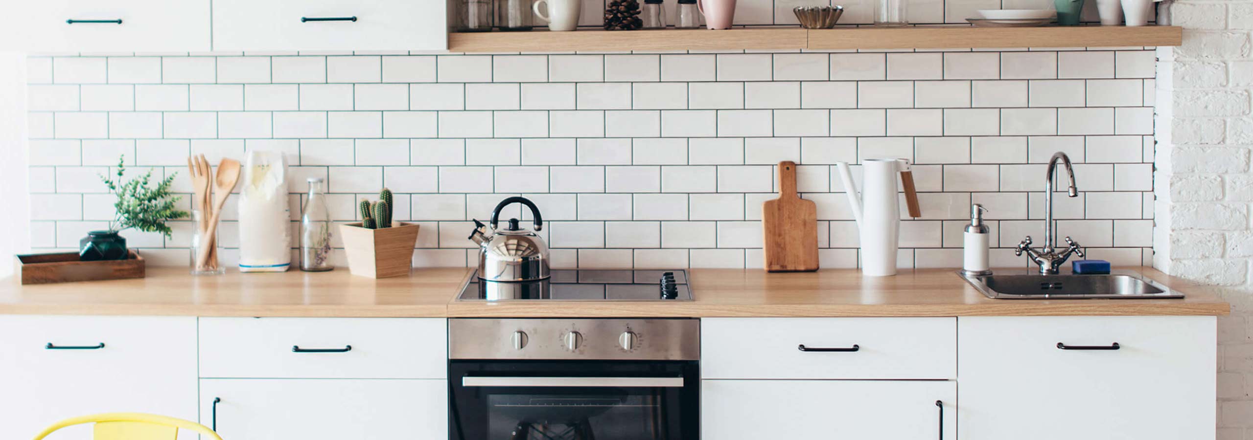 A bright, modern kitchen interior with white subway tile backsplash.