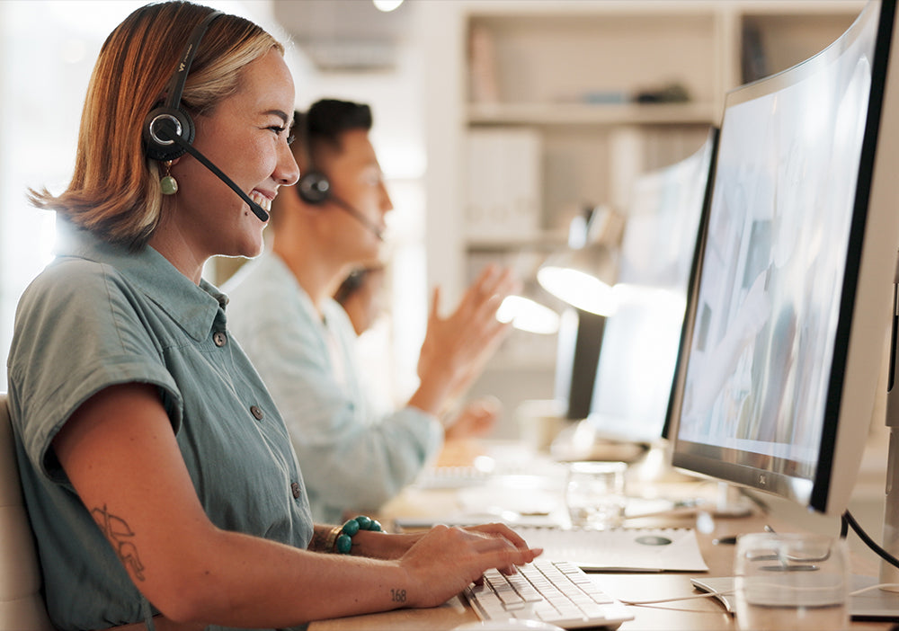 Person working at a computer with a headset in an office setting