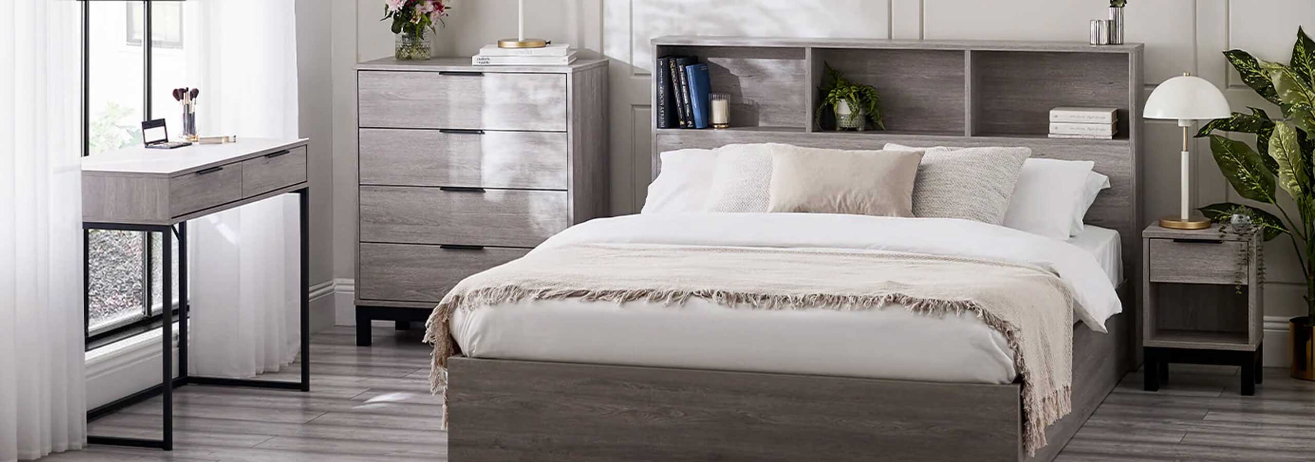 A bedroom scene featuring a gray wood platform bed with a built-in headboard and shelving