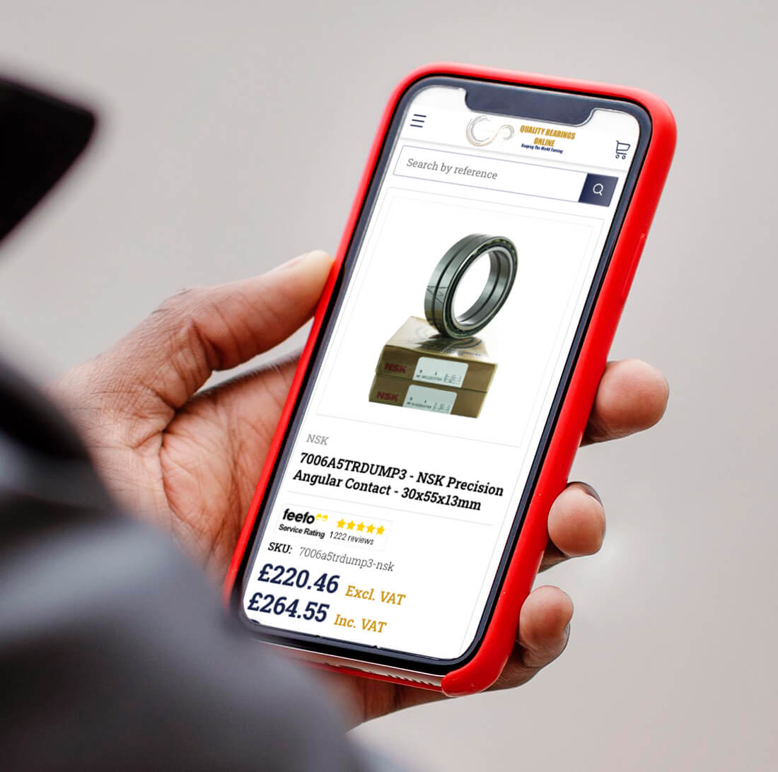 Shopify developer holding a phone device with a product page for Quality Bearings Online UK