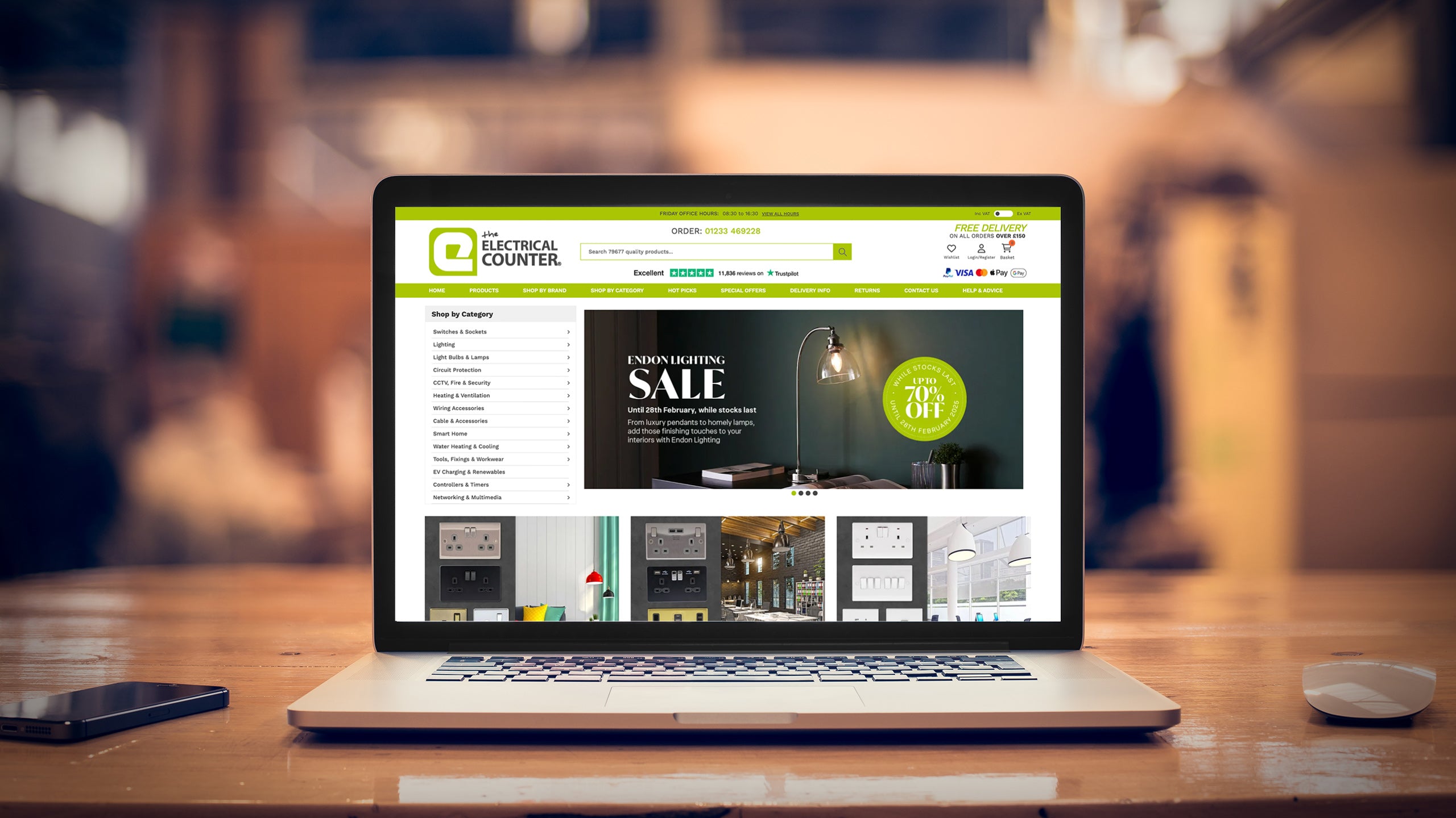 Laptop sitting on a wooden desk displaying The Electrical Counter Magento website design for the homepage